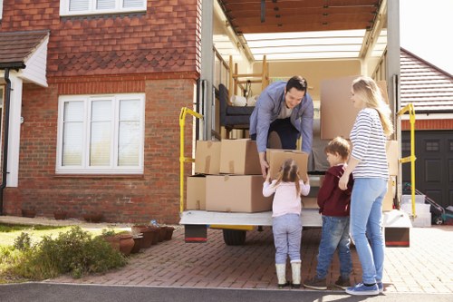 Local movers handling fragile items with packing materials in Merton